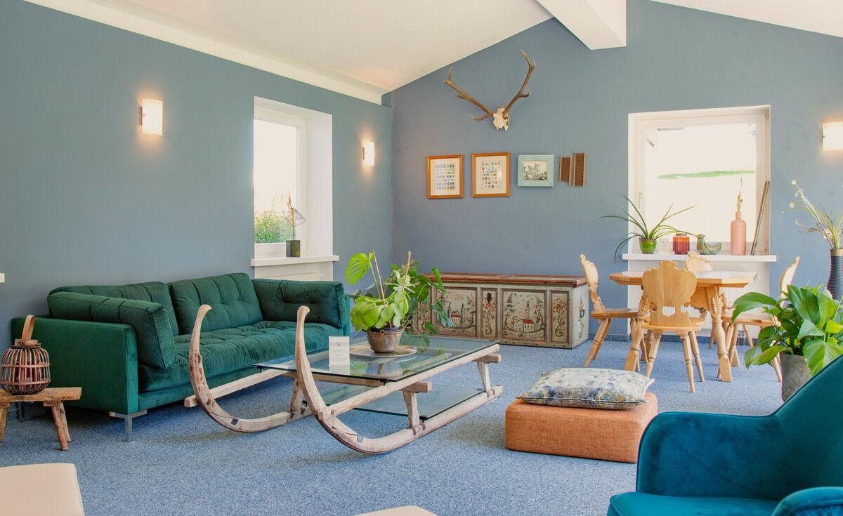 Blue lounge with a historic horn sledge and seating group.