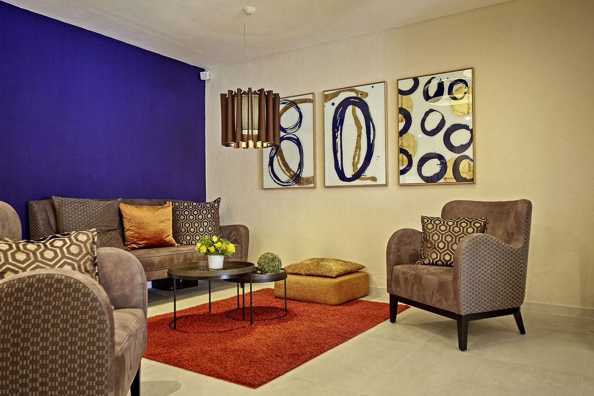Lounge with a purple wall, armchairs and a red carpet.