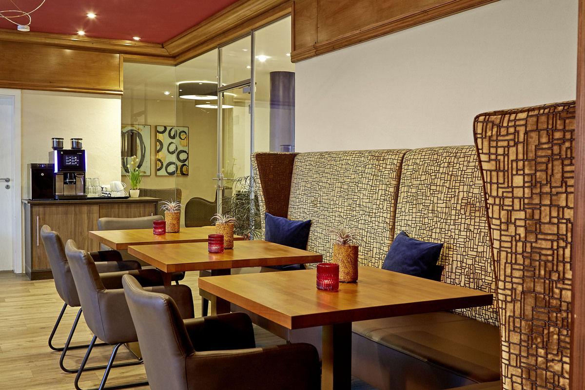 Restaurant with laid tables and a woven room divider.