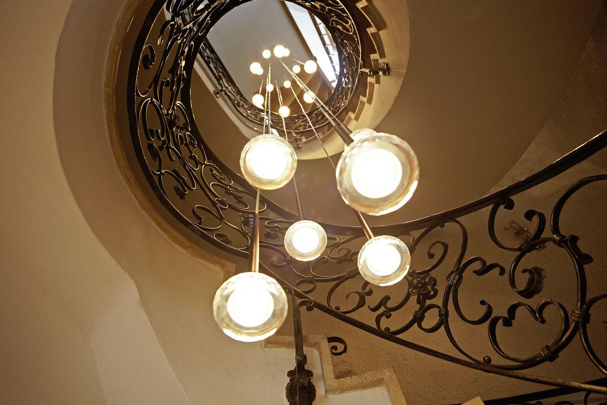 Stairwell with a curved wrought-iron banister and a modern globe light.