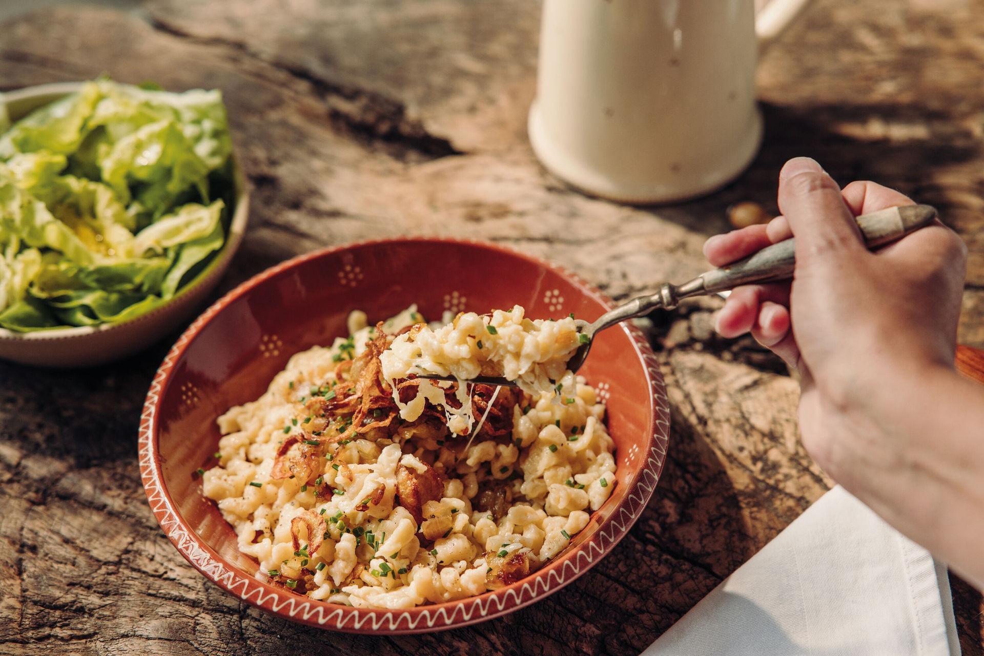 Allgäuer Käsespätzle mit Röstzwiebeln im Restaurant des Hotel Bavaria.