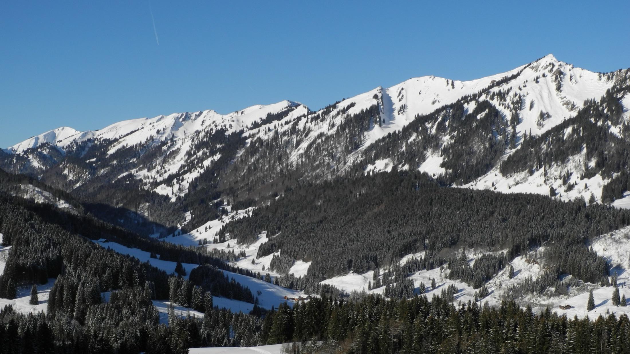 The snow-covered Nagelfluhkette ridge above the Allgäu foothills on a clear winter day.